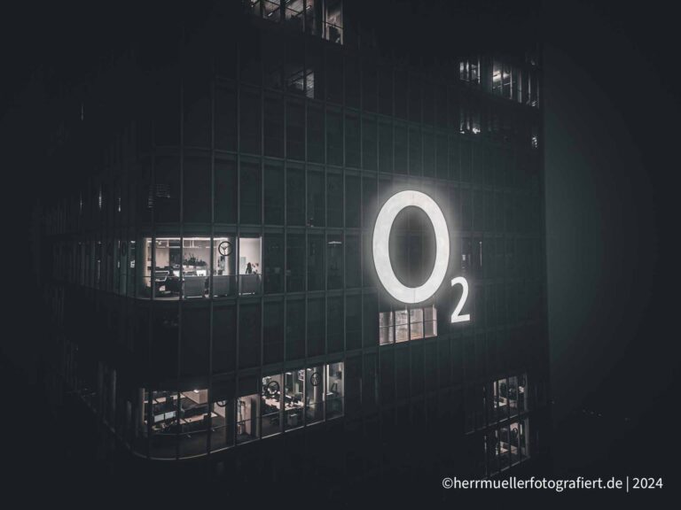 Das strahlende o2 Logo am o2 Tower bei nebliger Nacht
